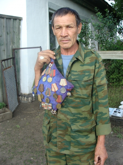 Сын К. М. Тюзюльбаева с наградами отца.